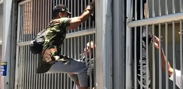 Candidato tentando pular o portão